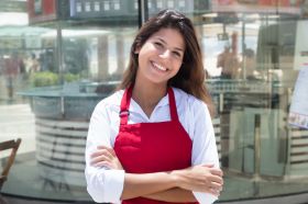 Foto: Junge Kellnerin vor dem Restaurant
